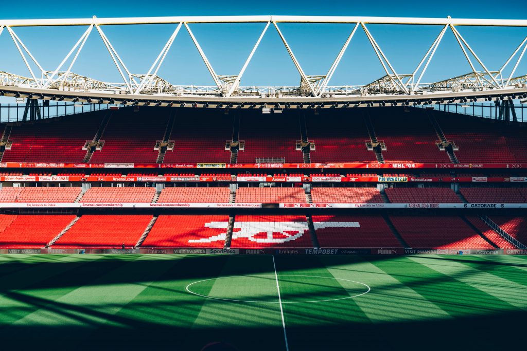 the inside of the emirates stadium showing the pitch and half of the seating