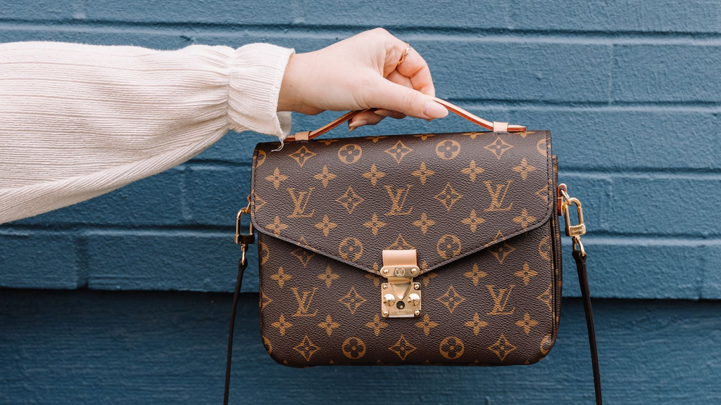 a louis vuitton handbag being held up to the camera