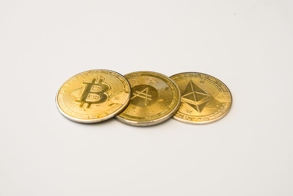 three golden coins. one has bitcoin logo one has ethereum logo